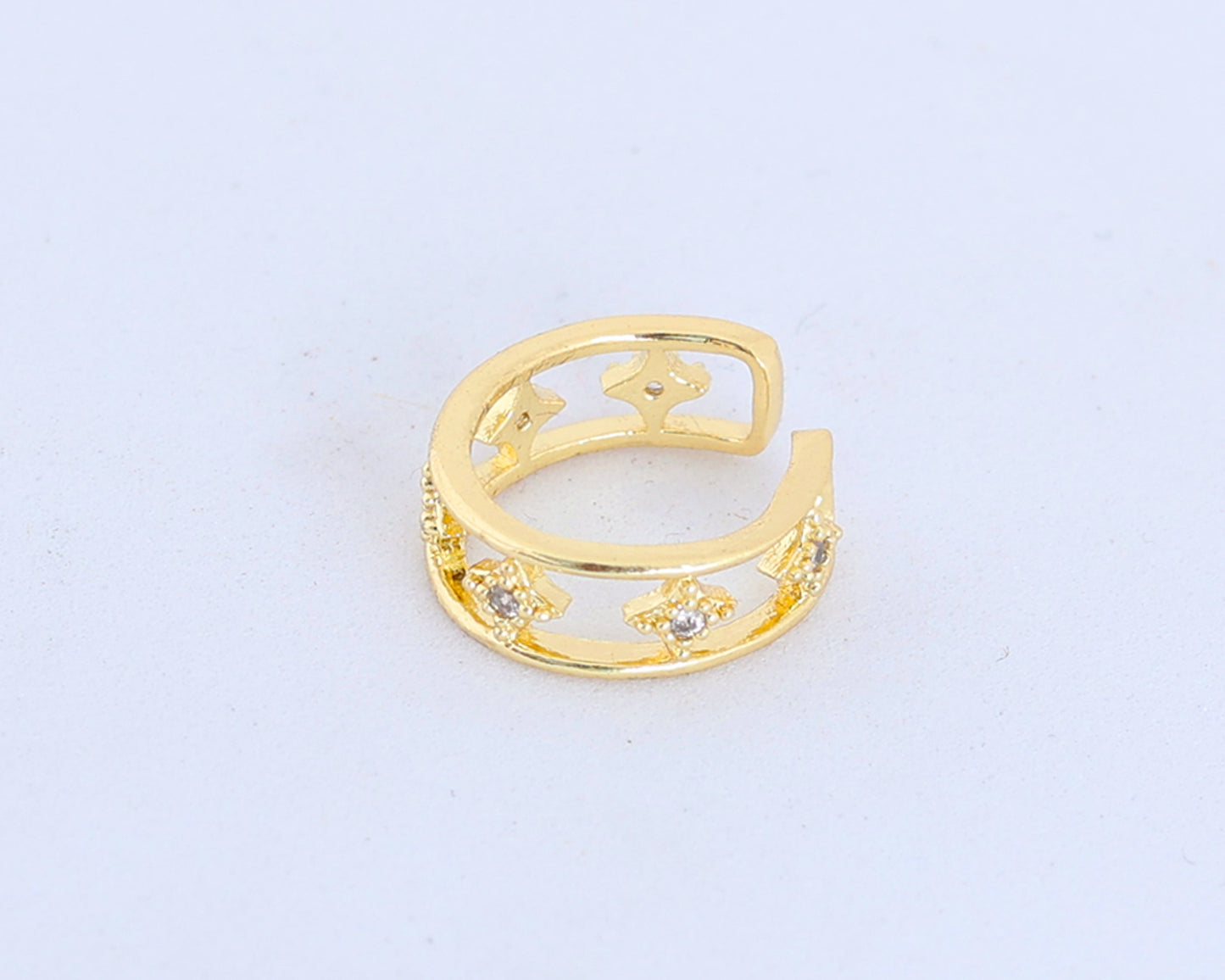 The Small Gold Ear Cuff is gold plated with an open design, featuring star-shaped cutouts and lab-created stones, shown on a plain white background.