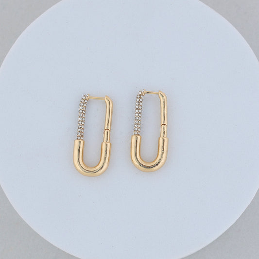Long Rectangle Gold Hoops with rounded edges, each adorned with a row of sparkling zircon stones on one side, displayed against a white circular background.