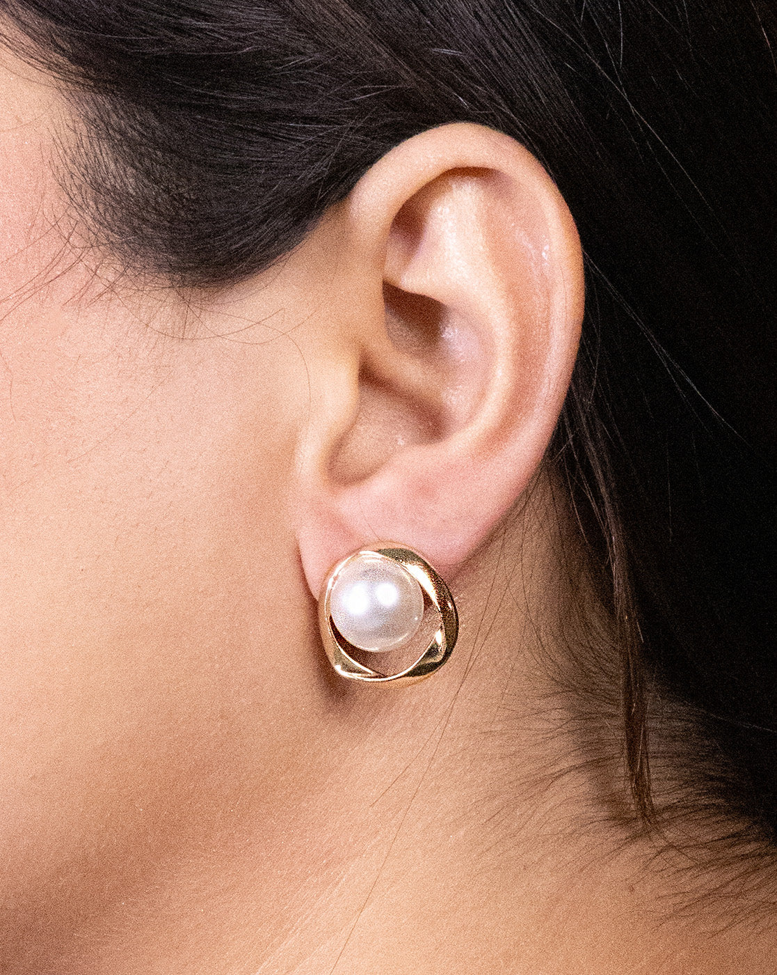 A close-up shows a woman's ear with dark hair, wearing Vintage gold and pearl earrings—each featuring a large round white pearl set in a gold-plated frame.