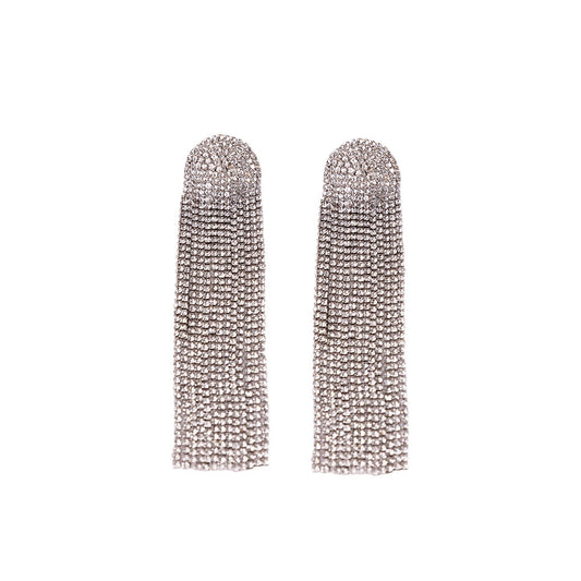 The Zircon Shimmer Tassel Earrings feature long, silver-toned rhinestone tassels crafted from brass alloy with multiple dangling strands, displayed flat on a white background.