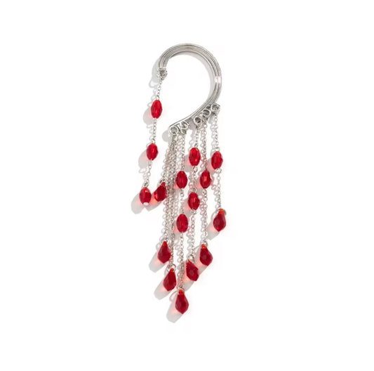The Red Beads Ear Cuff (left ear) features cascading chains adorned with small red teardrop beads, shown against a white background—an elegant accessory for standout style.