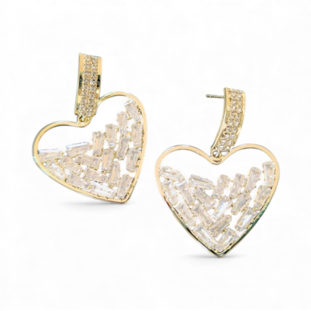 The Hollow Hearts Earrings are gold, heart-shaped 24K gold plated with open centers, featuring lab created rectangular clear gemstones and small round stones on the hooks, displayed on a white background.