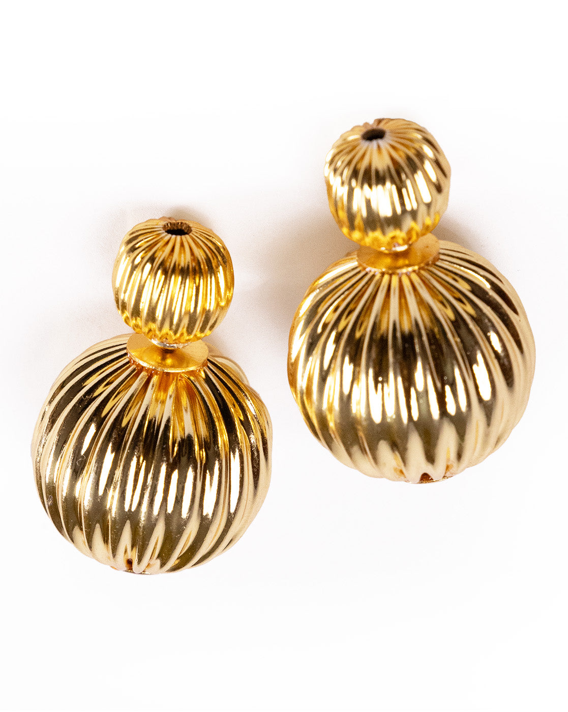 Close-up of textured striped gold earrings showing fine detailing