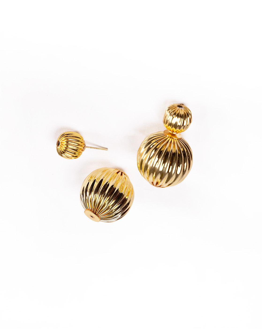 Close-up of textured striped gold earrings showing fine detailing