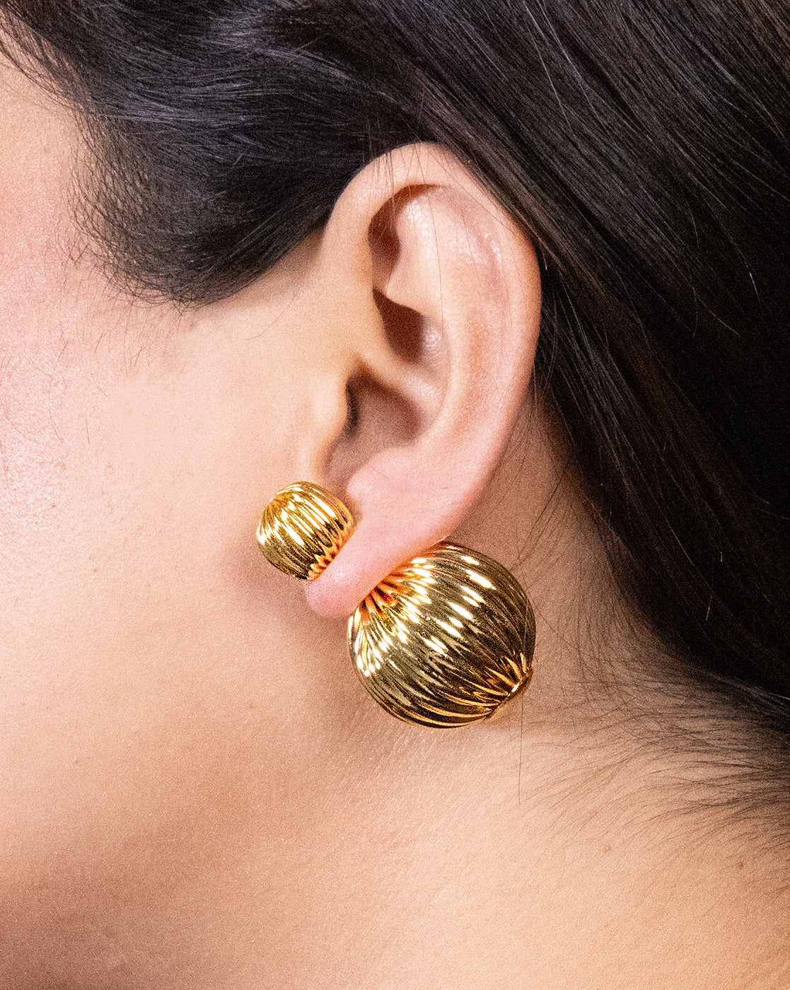 Lightweight striped gold earrings worn as everyday jewelry