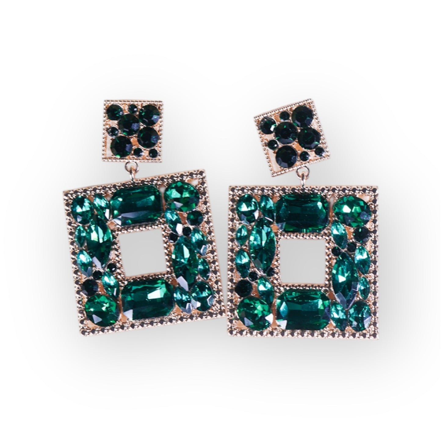 The Green Goblin Earrings are gold plated statement earrings with a square stud and an offset rectangle, both adorned with green and blue gemstones and bordered by small clear stones.