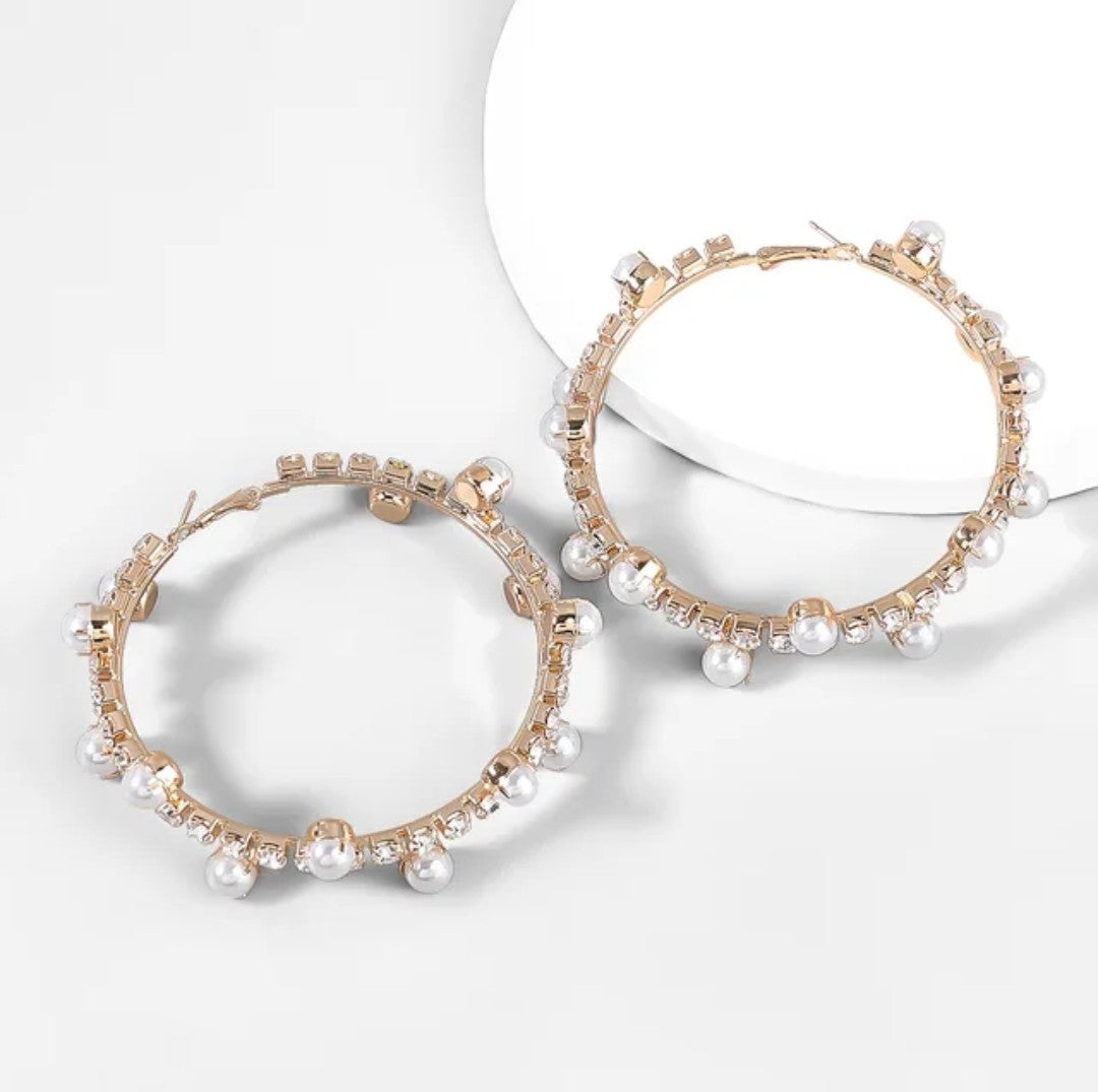 The Gold Pearl and Crystal Hoops feature gold plating adorned with small pearls and clear crystals, shown on a white background with soft shadows—an elegant choice for your luxury jewelry collection.